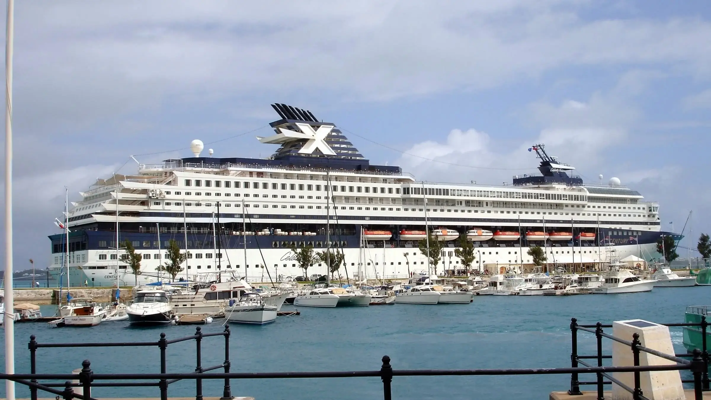 A cruise ship berthed at King's Wharf in the Royal Naval Dockyard, Bermuda, with yachts in the marina in front